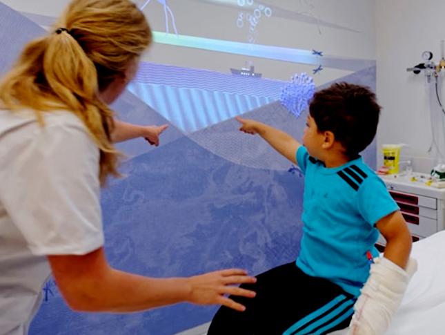 A child interacting with a projected image in a hospital.