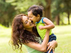 Woman embracing her child outside.