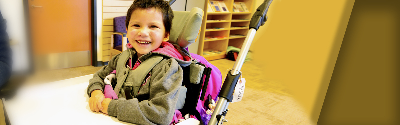 A child smiling in a chair.