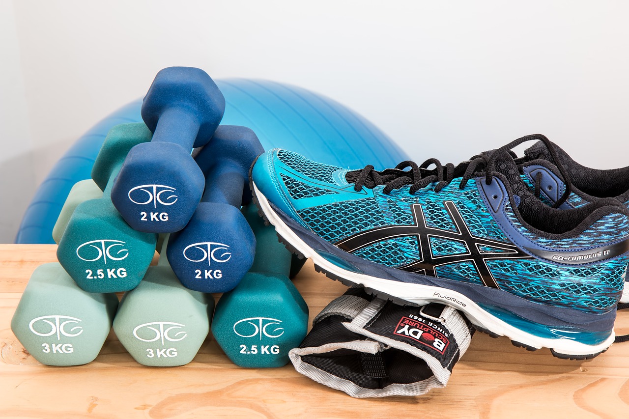 A photo of weights, tennis shoes, and an exercise ball