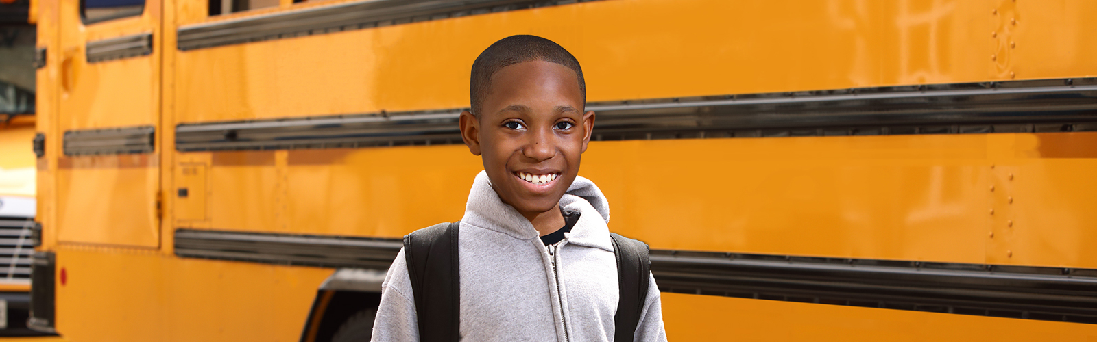 Mikey Standing in front of a school bus