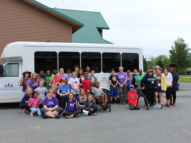 Camp SOAR participants photographed outside of a Kennedy Krieger bus
