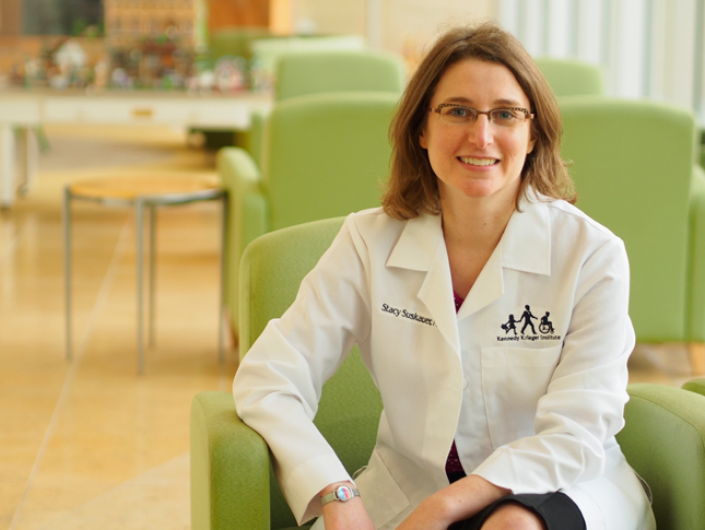 Dr. Stacy Suskauer sits in a green chair in the lobby of the Kennedy Krieger outpatient building at 801 N. Broadway