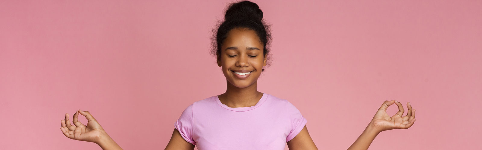 Smiling teenage girl meditates. 
