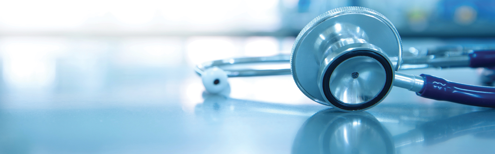 A stethoscope for sits on medical laboratory table. The background of the image is faded.