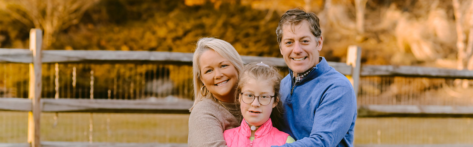 A Kennedy Krieger patient and her parents smile in their backyard.