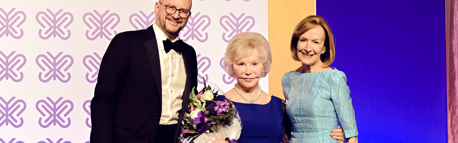 Dr. Bradley Schlaggar, Dr. Nancy Grasmick and Judy Woodruff stand on stage at the 2025 Champions of Hope Gala.