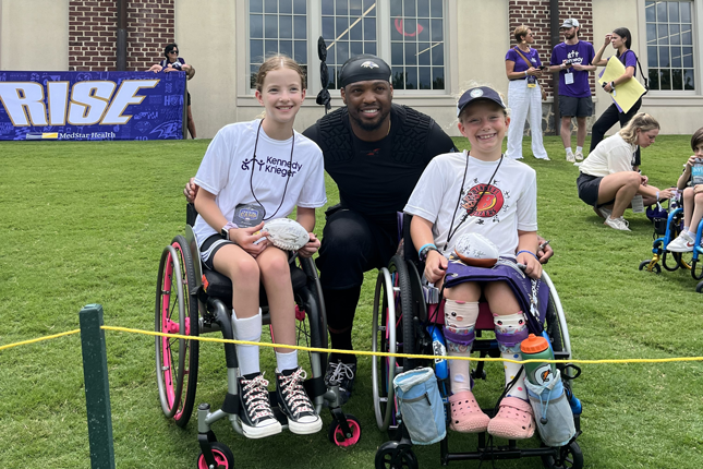 Ravens running back Derrick Henry with two members of the Bennett Blazers adaptive sports team.