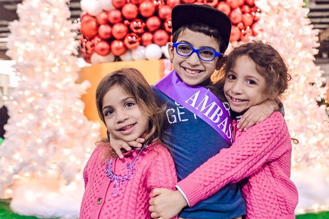 A Kennedy Krieger ambassador and his two sisters at Festival of Trees.