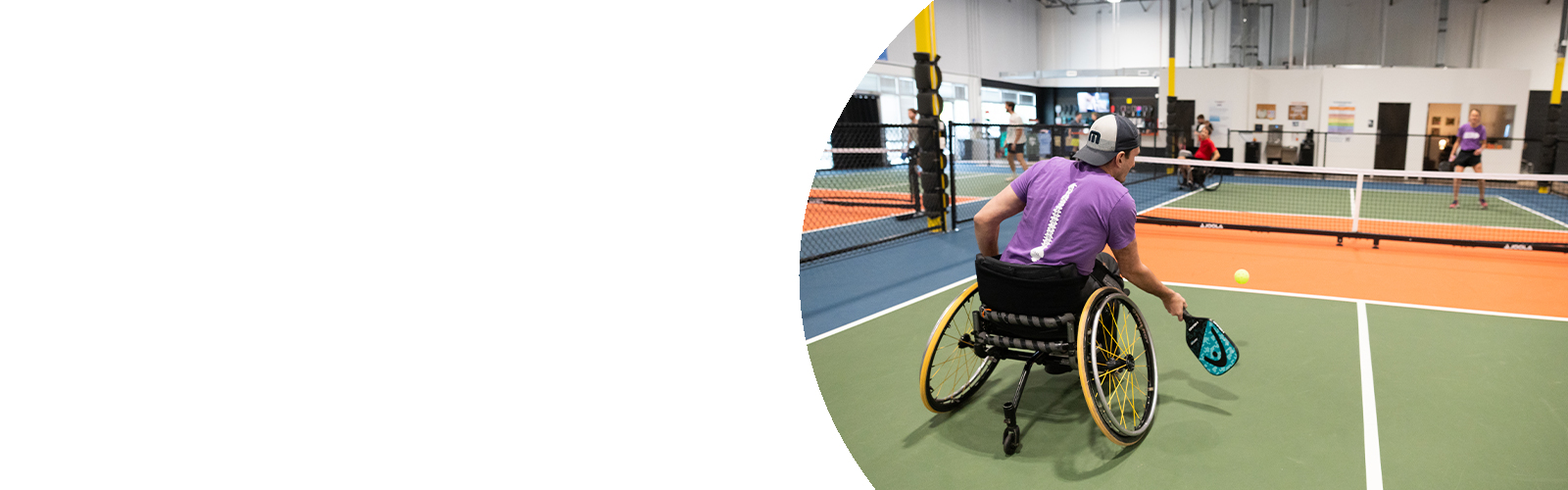 An adaptive and non-adaptive athlete playing pickleball.