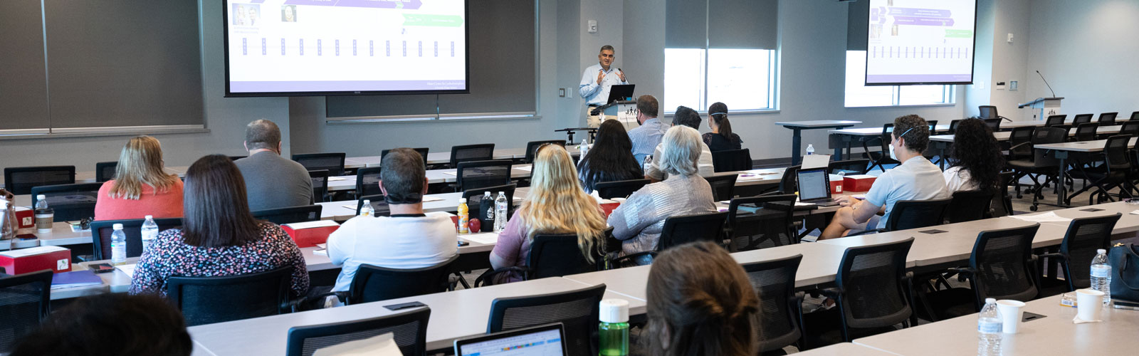 A presenter speaks inside a conference room during the LBSL Patient and Scientific Conference.