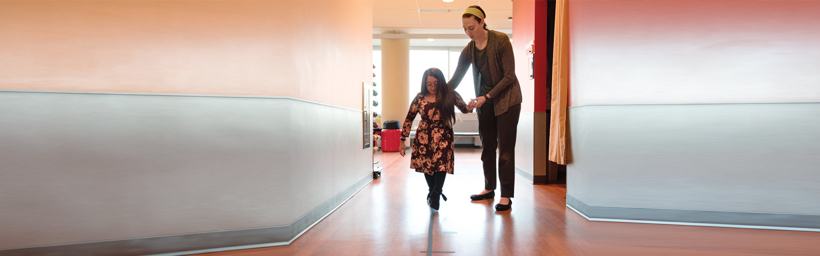 Shannon and her therapist walk down a corridor at Kennedy Krieger