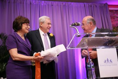 Dr. Arlene Forastiere, Dr. Gary Goldstein, and Mike Batza behind a podium on the stage.