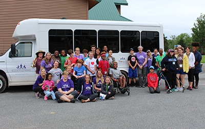 Camp SOAR campers in front of a Kennedy Krieger bus.