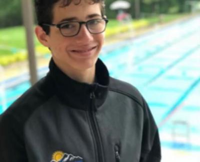 Josef Kay standing next to a pool, smiling.