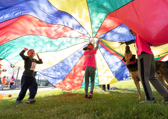 Kids play a parachute game at ROAR 2022.