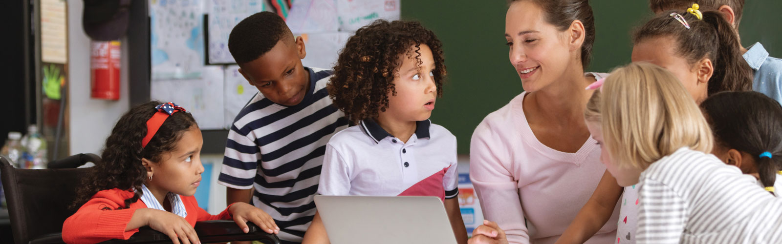 A group of students gather around a teacher.