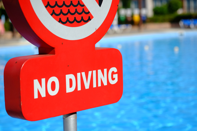Closeup of a poolside sign that reads, No Diving.