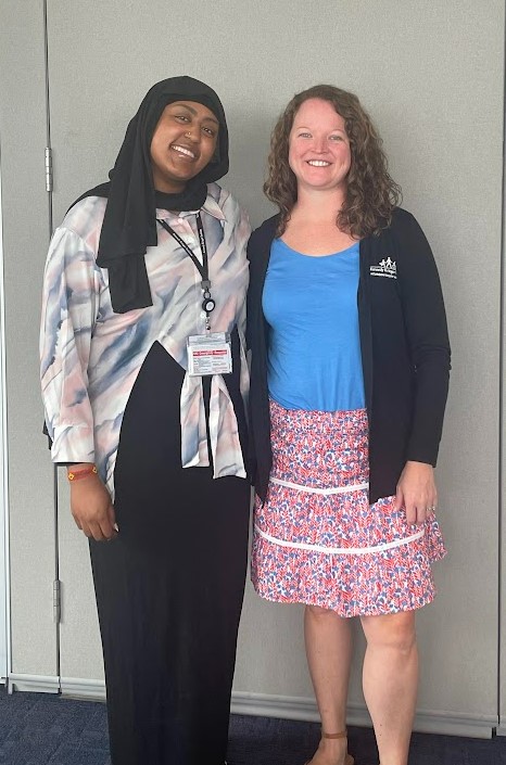 Bulo Osman stands for a photo with Neurodiversity at Work staff member Rebecca Colangelo.