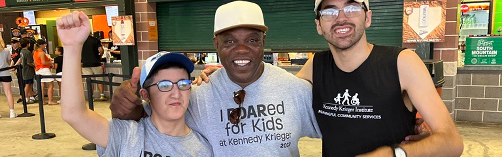 Three men from the Neurodiversity at Work program stand in a group photo on the concourse of Ripken Stadium in Aberdeen, MD.