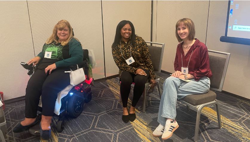 Three women sitting down smile for a photo at the People on the Maryland Conference.