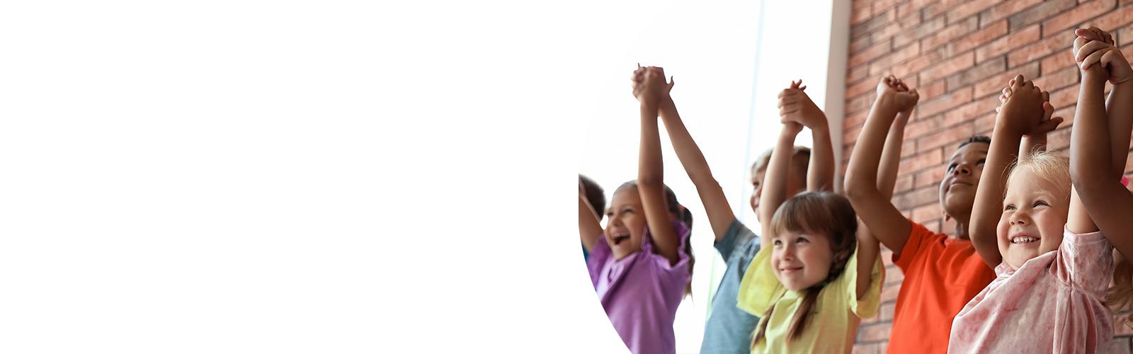 A group of children raising their hands.