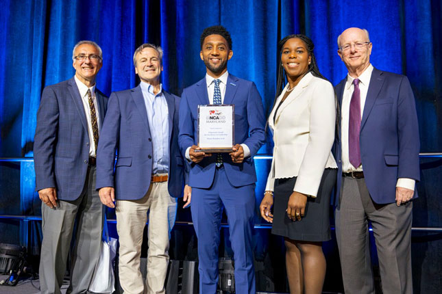 Dr. Mirian Ofonedu, along with three man, in a group photo with Baltimore City Mayor Brandon Scott. Scott is standing in the middle, while Dr. Ofonedu is immediately to his right.