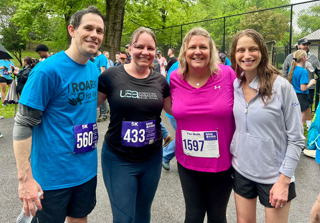Four MCDD staff members, including a man and three women, at ROAR. All four are wearing athletic apparel, with three of them wearing racing bibs.