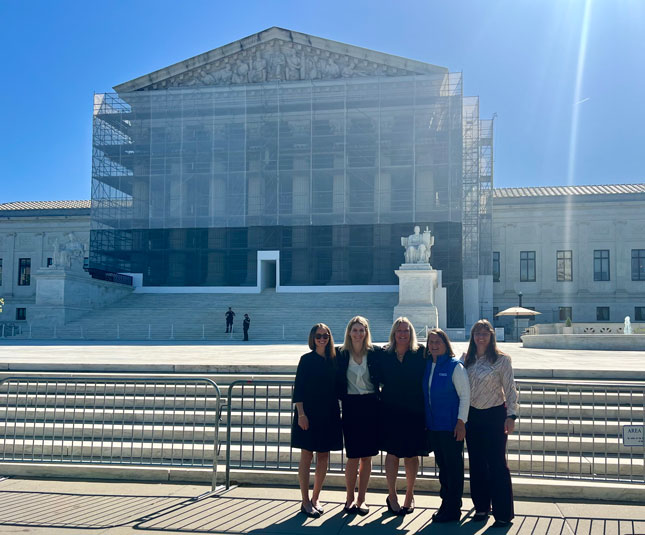 Legg, Waller, van Stone, Genevieve Hornik and another woman in front of the U.S. Supreme Court building.