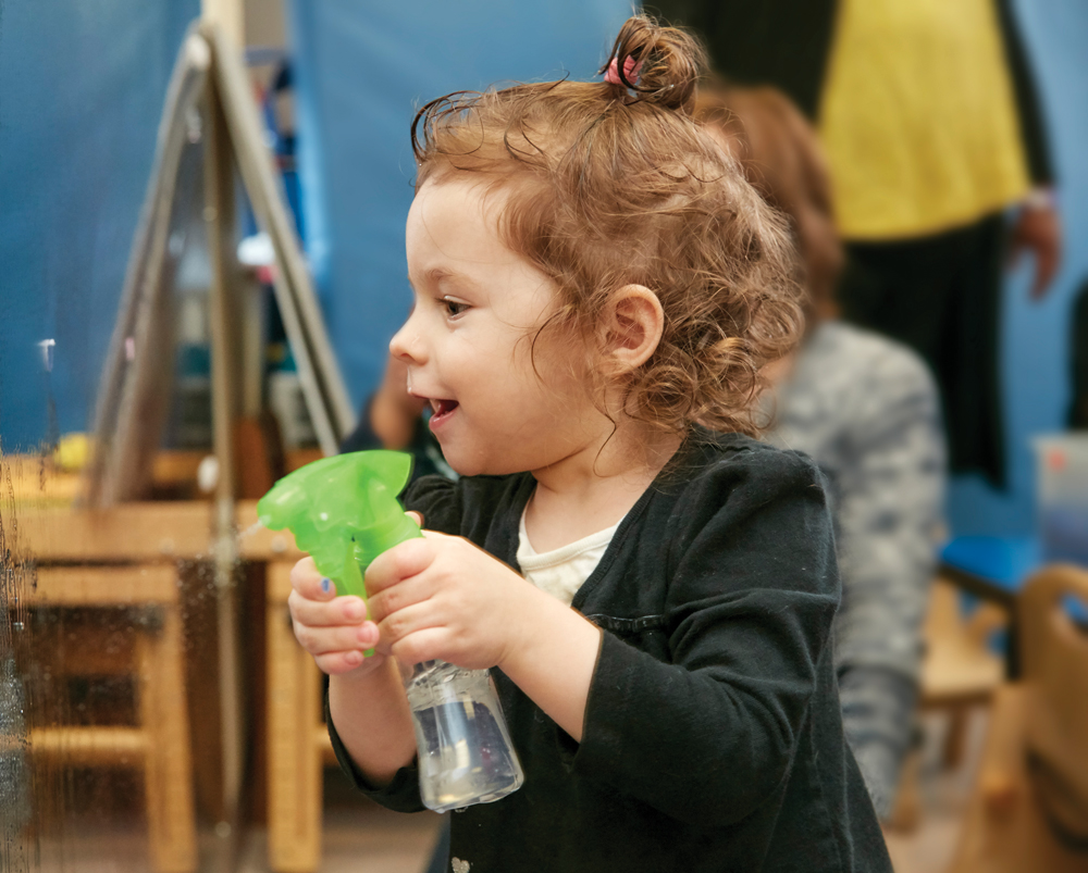 A child holding a spray bottle.