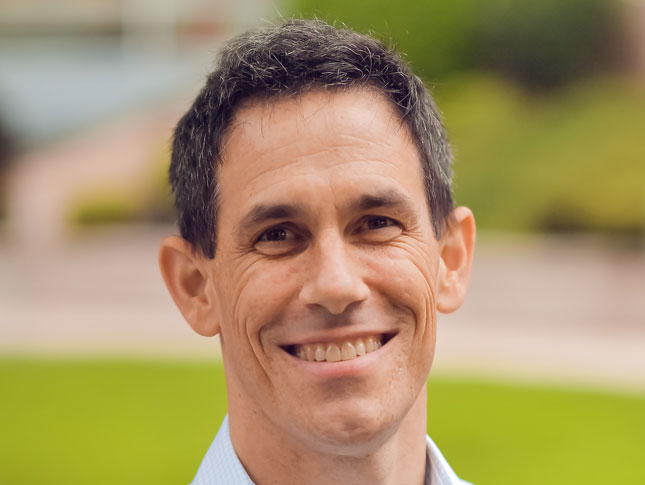 David Mervis headshot. The image was taken outside.