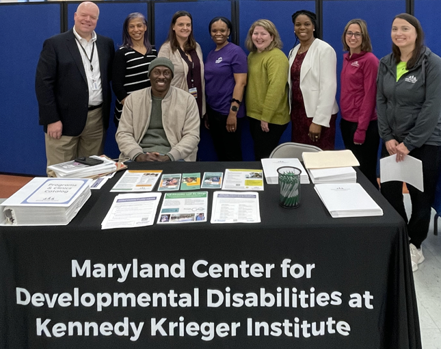 Nine people behind MCDD's table at the Howard County Public Schools Special Education Resource Fair.