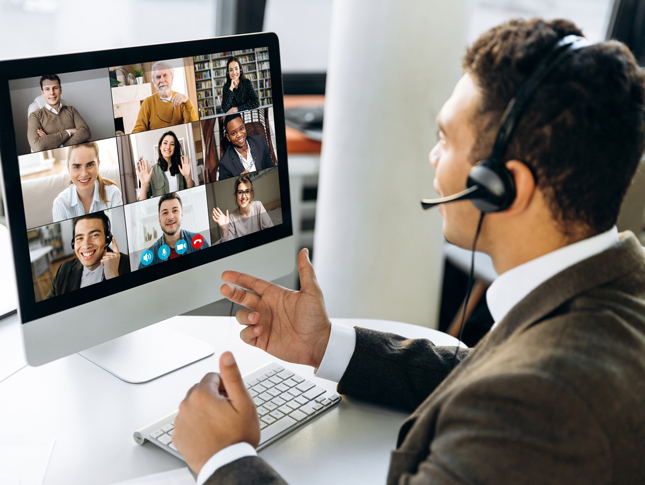 A man talks during a webinar. Nine participants are seen on his monitor.