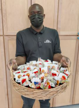 A Project SEARCH intern holds a basket of goods.