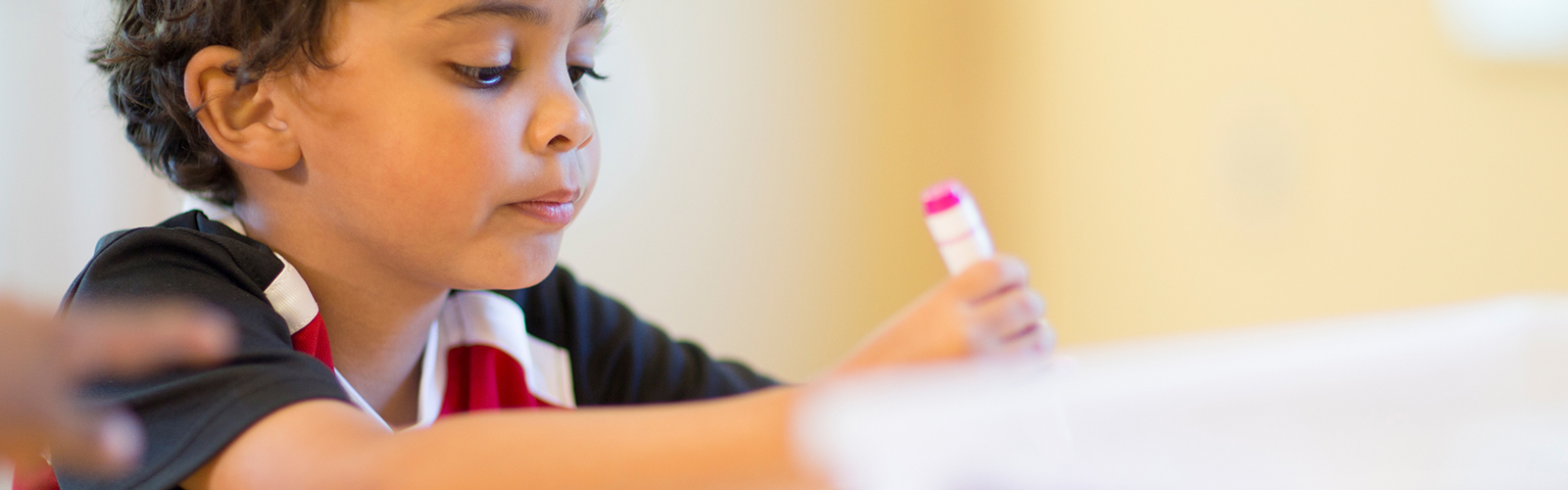 A boy writes with a magic marker.