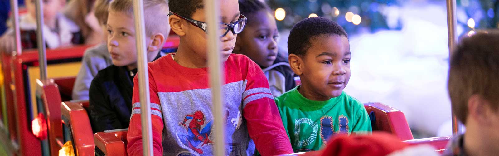 Children sit on a ride at Festival of Trees. 