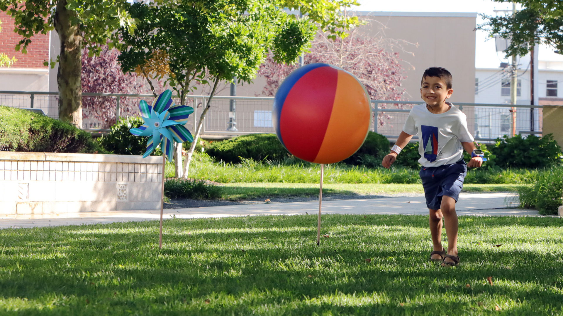 Daniel chases a beach ball in Kennedy Krieger's therapy garden