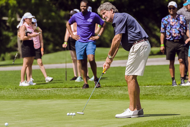 A male golfer makes a put at the 4th annual CASSI Golf Outing.