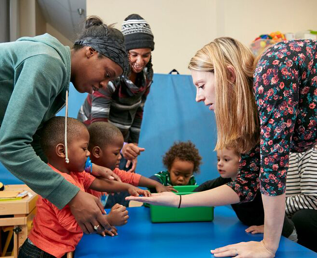 A group of therapists assist children in the Early Explorers Preschool Group.