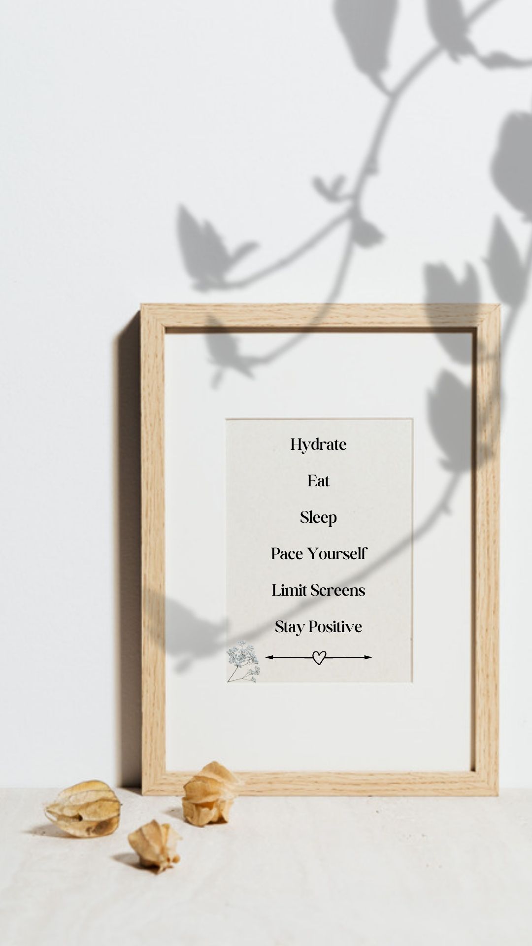 A light brown frame is propped against the wall with seashells laying off to the side. Text inside the frame reads  In a pink square over her back, there is black text that reads hydrate, eat, sleep, limit screens, pace yourself, stay positive.