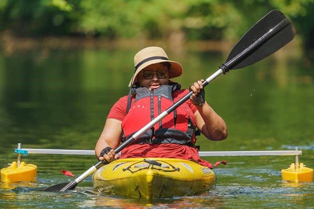 An adaptive sports athlete participates in an adaptive paddling event.