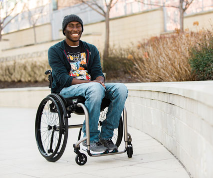 A male patient sits in a wheelchair in Kennedy Krieger's Therapy Garden.