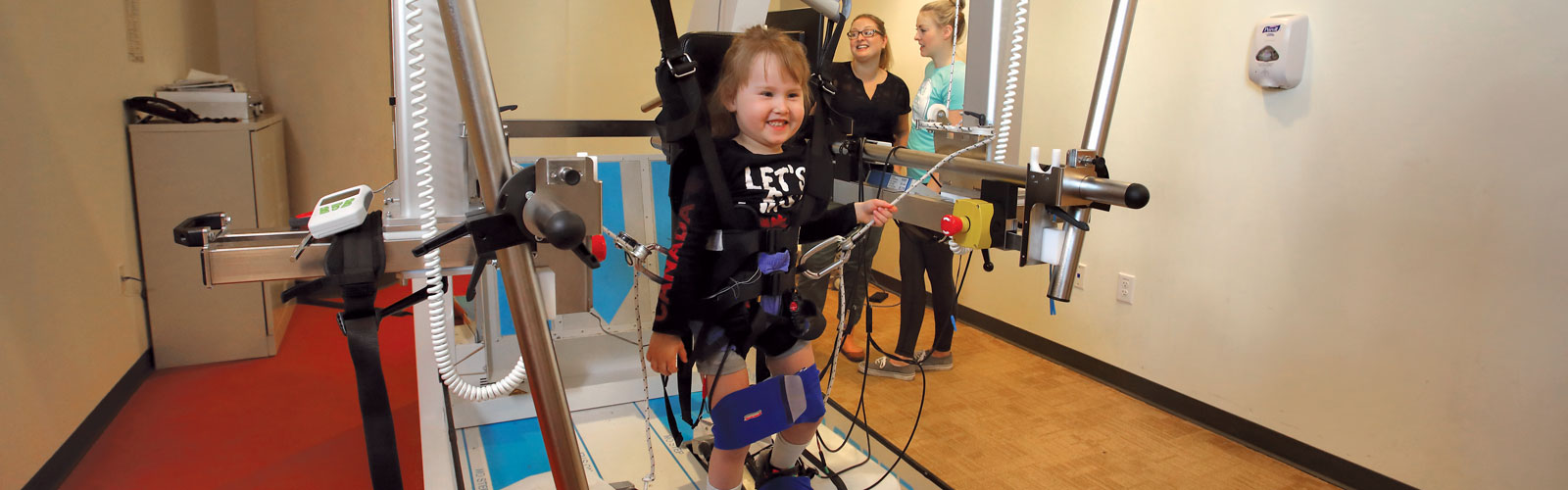 A child in a device to help with spinal cord injury.