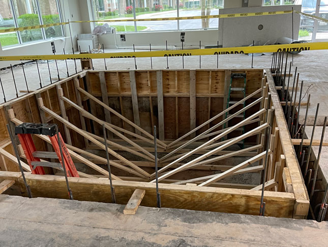 The hole for the under-construction pool inside of ICSCI's White Marsh location. Yellow caution type surrounds the hole.