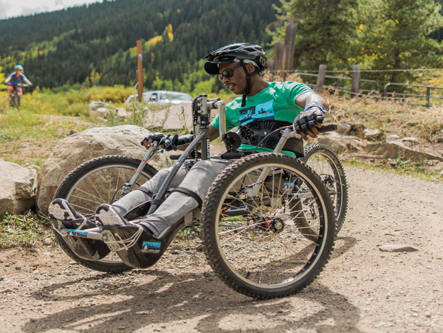 A male adaptive sports athlete rides a mountain bike. 