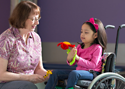 A patient in a wheelchair sitting with a doctor.