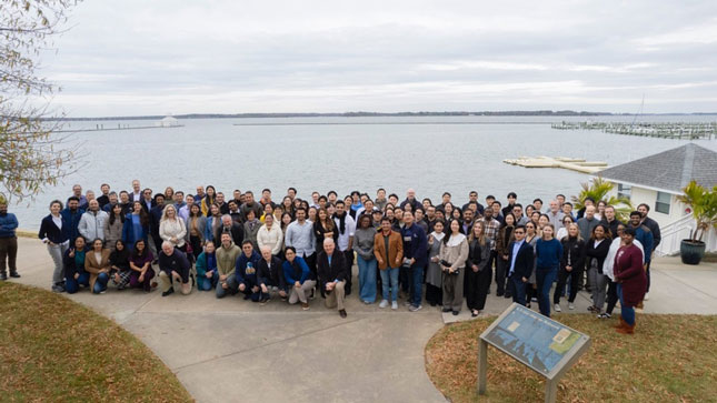 A large group stands on a promenade overlooking a lake at the 28th MRI Division retreat.