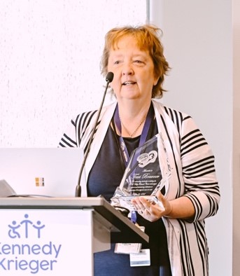 Terri Brawner stands at a podium and speaks after receiving an exceptional performance award.