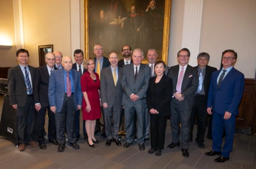 A group of people dressed in professional attire stand for a photo.