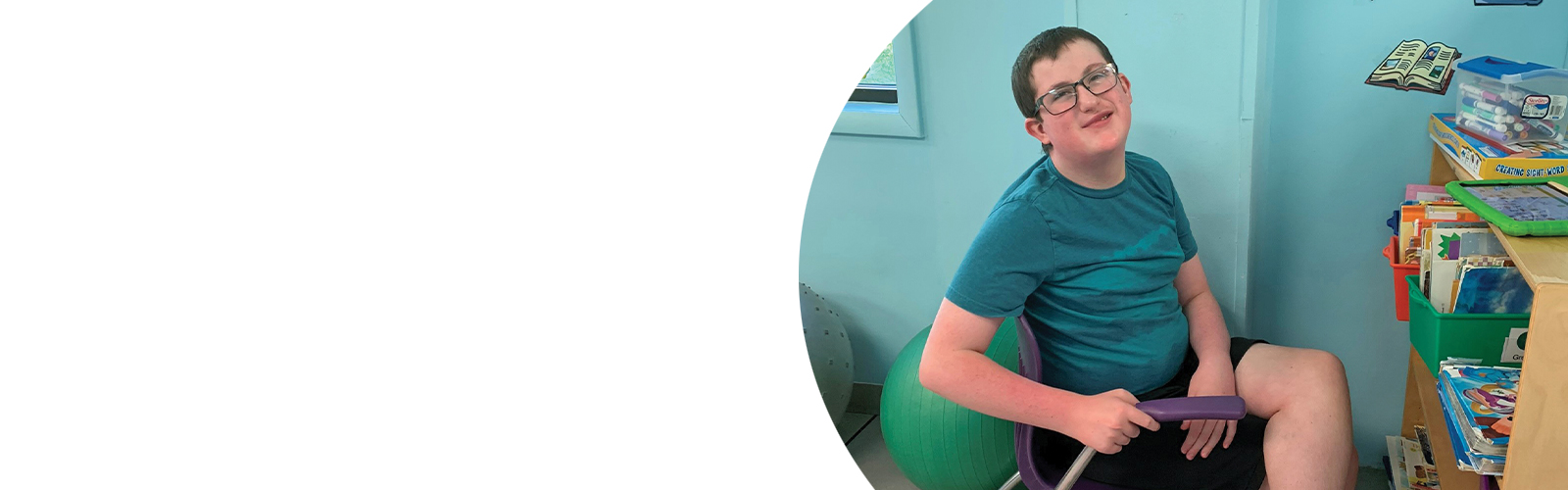 A LEAP student smiles while sitting in a classroom.